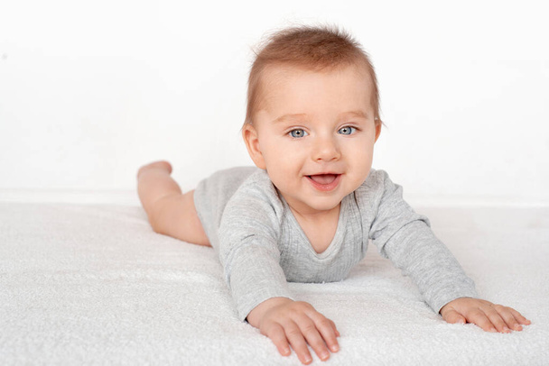 Portrait of a cute baby boy with blue eyes on white background. Healthy childhood innocence concept. - Φωτογραφία, εικόνα