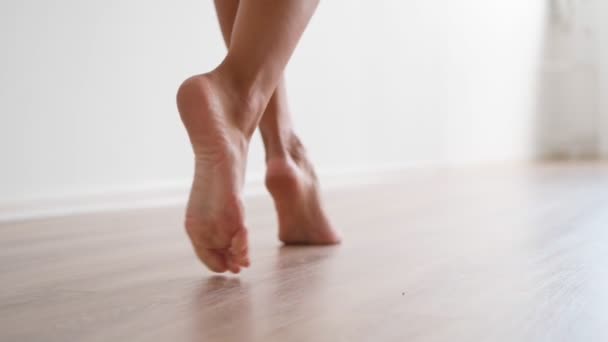 Slim female bare feet walking white wall. Attractive legs woman gracefully walk  - Footage, Video