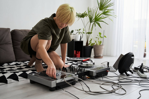 Woman turns the regulators at the dj console - Foto, afbeelding