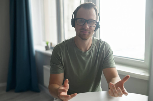 Video conference with a confident male employee in headset - Foto, imagen