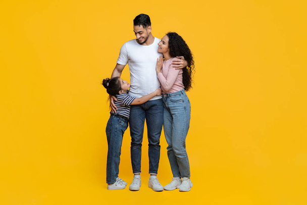Happy Middle Eastern Family Of Three Standing Isolated Over Yellow Background - Photo, Image