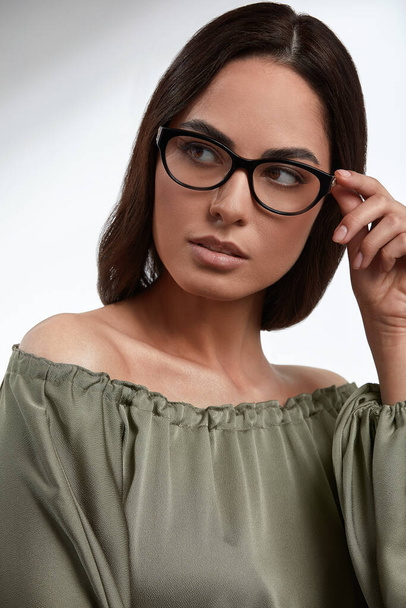 Stylish young brunette in a green dress and glasses, magazine cover, fashion industry, successful business woman. - Foto, Bild