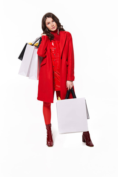 Girl standing with a lot of shopping bags over white background - Foto, imagen
