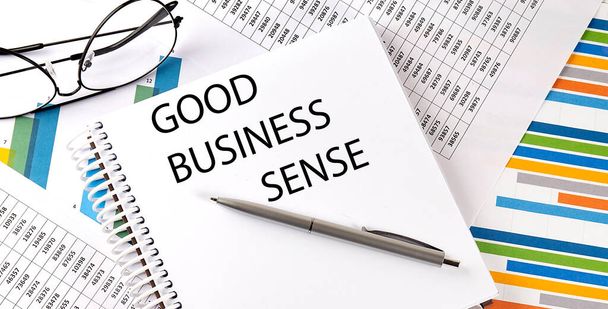 Ноутбук с текстом Good BUSINESS SENSE. Диаграмма и белый фон - Фото, изображение