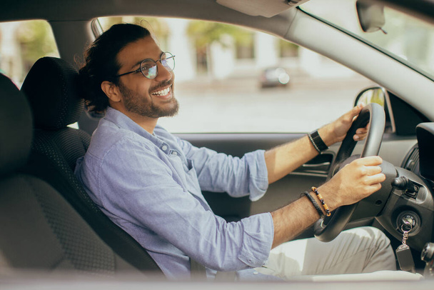Bello indiano che guida auto, guardando lo specchio retrovisore - Foto, immagini