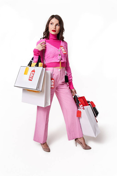 Woman holding many paper shopping bags at studio - Valokuva, kuva