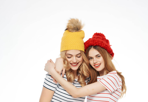 duas mulheres abraçando em bonés amizade emoções luz fundo - Foto, Imagem