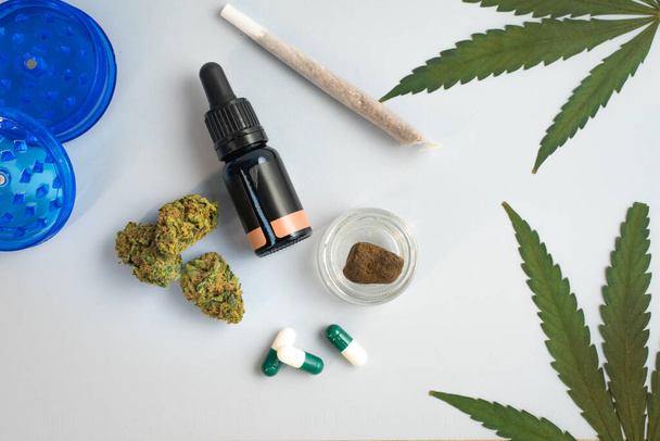CBD oil, capsules and hemp buds on white background. Organic and natural hemp-based cosmetic and beauty products. Medical cannabis concept. Alternative medicine. Copy space for text. - Foto, imagen