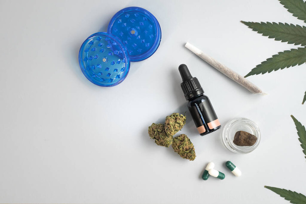 CBD oil, capsules and hemp buds on white background. Organic and natural hemp-based cosmetic and beauty products. Medical cannabis concept. Alternative medicine. Copy space for text. - Zdjęcie, obraz