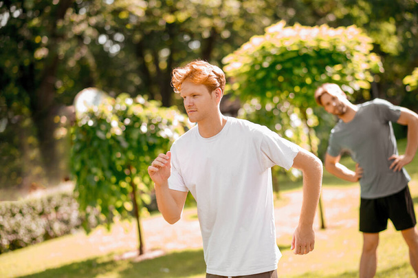 Ragazzo dai capelli rossi su mattina jogging e warm-up amico - Foto, immagini