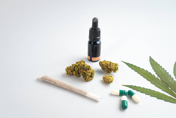 CBD oil, capsules and hemp buds on white background. Organic and natural hemp-based cosmetic and beauty products. Medical cannabis concept. Alternative medicine. Copy space for text. - Foto, Imagen