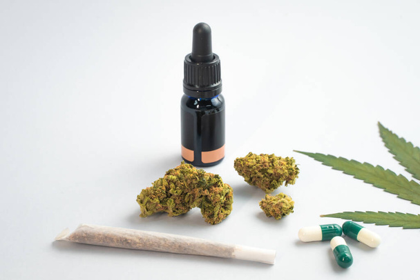 CBD oil, capsules and hemp buds on white background. Organic and natural hemp-based cosmetic and beauty products. Medical cannabis concept. Alternative medicine. Copy space for text. - Foto, Imagen