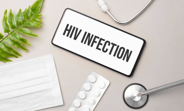 HIV infection word on smartphone,stethoscope and green plant - Valokuva, kuva