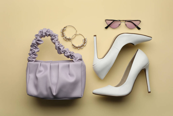 Stylish woman's bag, shoes, earrings and sunglasses on beige background, flat lay - Foto, Imagen