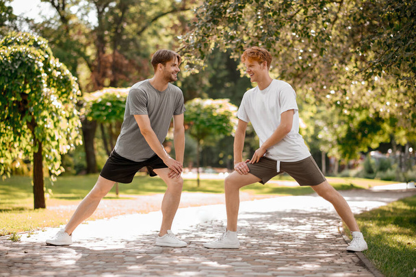 Two friends opposite each other doing stretching exercise - Photo, Image