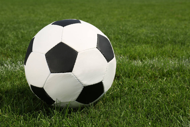 Football ball on green field grass outdoors. Space for text - Foto, Bild