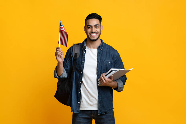 Smiling arab guy student showing flag of US - 写真・画像