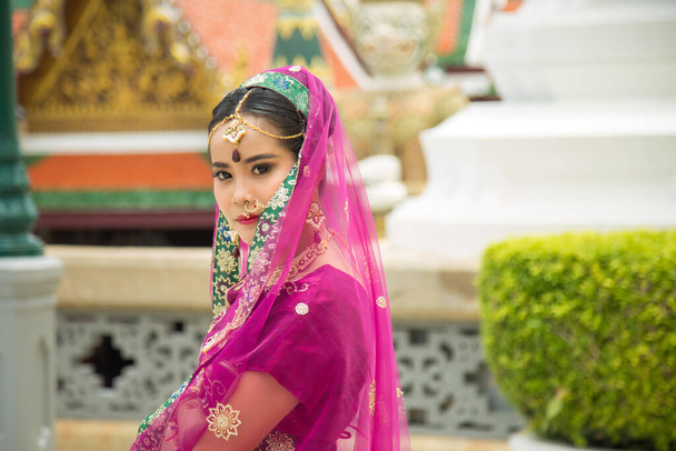Close up portret urocza Azjatka noszenie fioletowy indyjski tradycyjny sari ze ścianą w buddyjskim templ tle - Zdjęcie, obraz