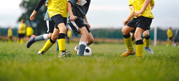 Grupa dzieci gra w piłkę nożną mecz Ligi. Piłkarze Running on Tournament Game. Dzieci grające w grę sportową na trawie miejsce - Zdjęcie, obraz