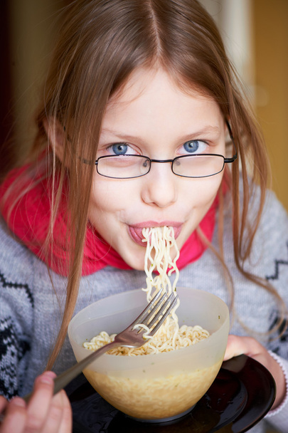 Little girl eating noodles - Foto, afbeelding