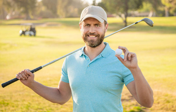 szczęśliwy człowiek pokazując piłkę gry w golfa na zielonej trawie, golf - Zdjęcie, obraz