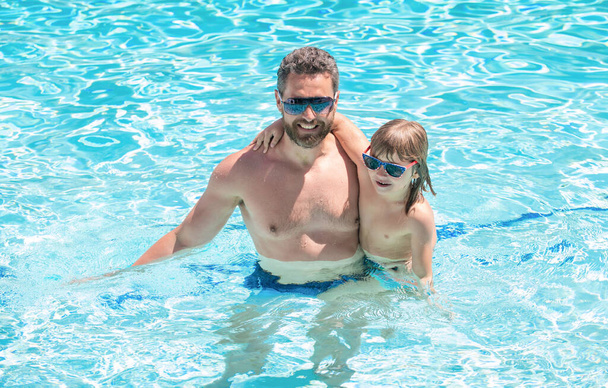 lapsuus ja vanhemmuus. Isä ja poika käyttävät silmälaseja uima-altaassa. - Valokuva, kuva