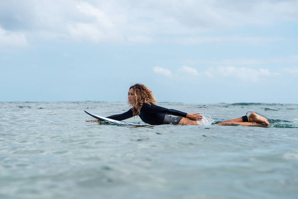 Muotokuva surffaaja tyttö valkoinen surffilauta sininen valtameri kuvassa vedestä Balilla - Valokuva, kuva