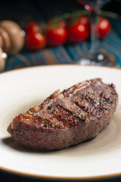 Roasted steak ,cherry tomatoes, salt and pepper on blue  wooden table. - Foto, Imagen