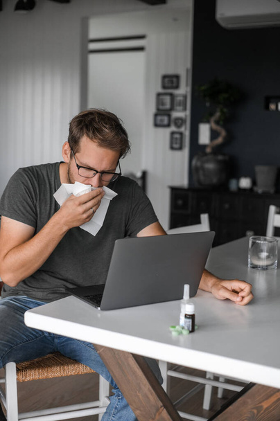 attractive nerdy man with glasses freelance working from home during the covid pandemic or flu - Fotoğraf, Görsel