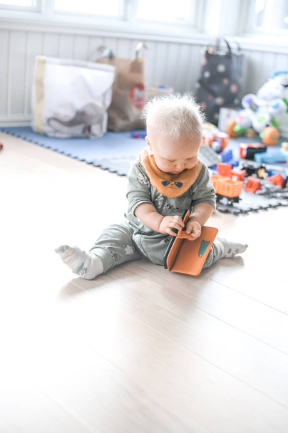 adorable cute baby boy playing with parents cell phone on the floor. happy childhood. - Фото, зображення