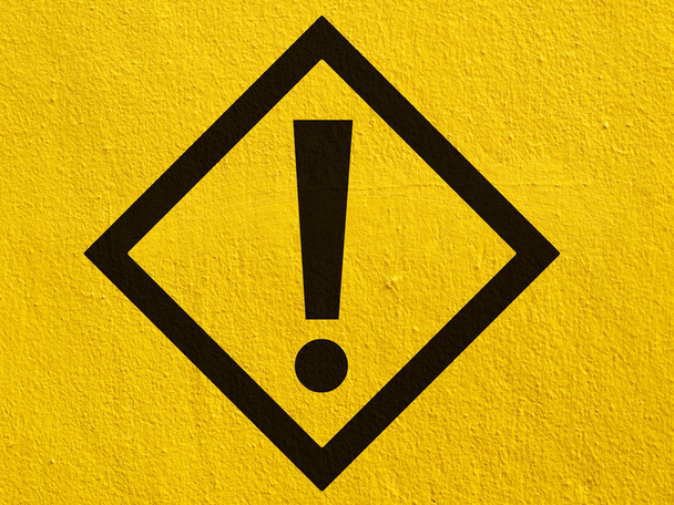 Un letrero de advertencia negro apunta pintado en una pared de estuco afuera
 - Foto, imagen