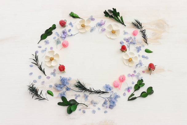 Top view image of pink, white, green and blue flowers composition over wooden background .Flat lay - Foto, Imagen
