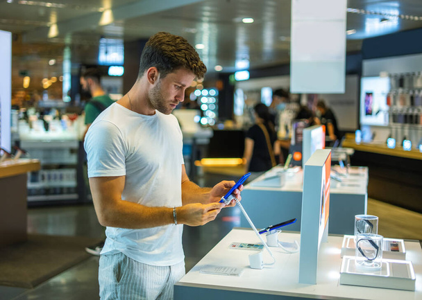 Customer checking phone in electronics store - Foto, Bild