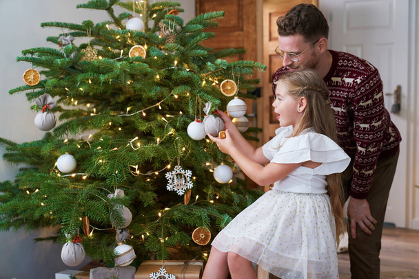 Πατέρας και κόρη διακοσμώντας το χριστουγεννιάτικο δέντρο - Φωτογραφία, εικόνα