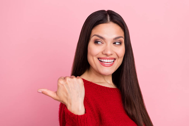 Photo of cheerful adviser girl indicate thumb empty space wear red pullover isolated pink color background - Fotoğraf, Görsel