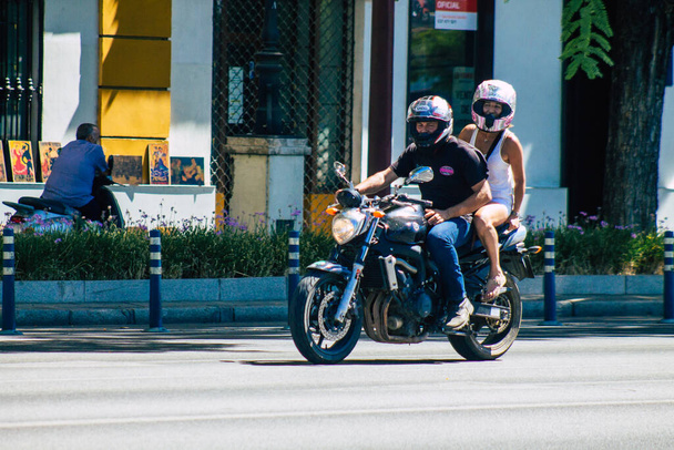 Seville Spain September 04, 2021 People rolling with a motorcycle in the streets of Seville, an emblematic city and the capital of the region of Andalusia, in the south of Spain - 写真・画像