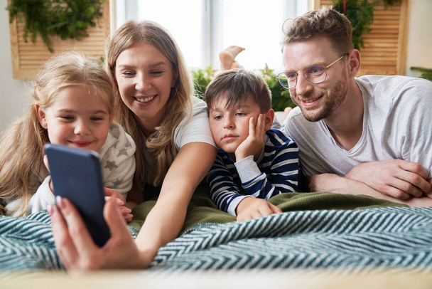 Familie nutzt Smartphone zu Weihnachten - Foto, Bild