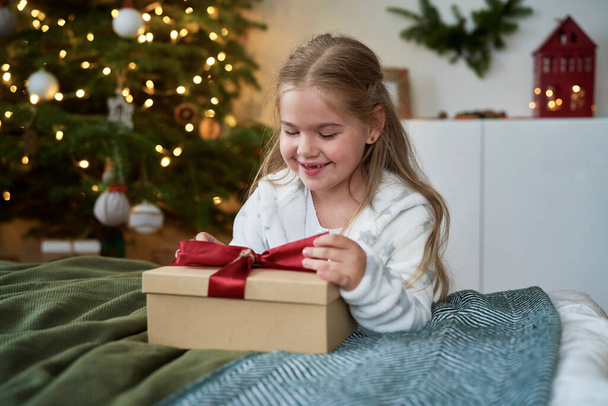 Little girl opening the Christmas present  - Fotó, kép