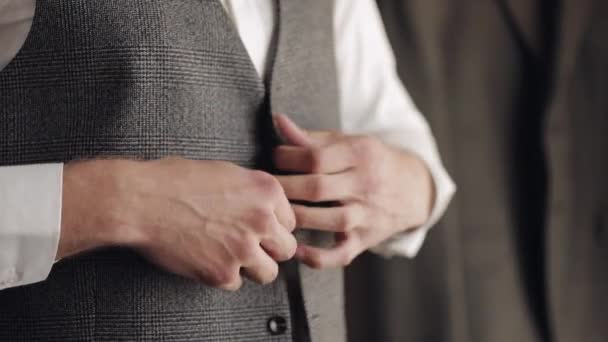 Veste boutonnière avec les mains fermées, l'homme en costume fixe des boutons sur sa veste se préparant à sortir - Séquence, vidéo