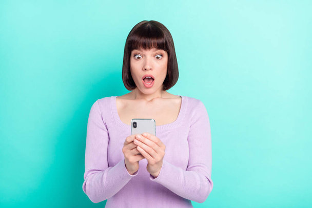 Portrait photo jolie femme stupéfaite choquée à l'aide d'un téléphone mobile isolé couleur turquoise vibrant arrière-plan - Photo, image