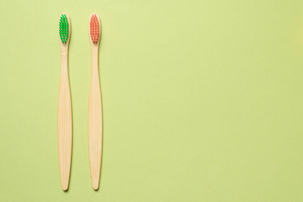 Bamboo toothbrush on a green background. Top view.  - 写真・画像