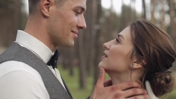 Newlyweds, caucasian groom with bride walking, embracing, hugs in park, wedding couple - Footage, Video