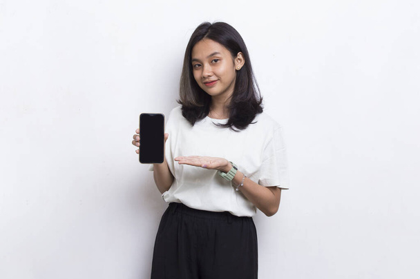 młoda piękna Azji kobieta demonstrujące telefon komórkowy odizolowany na białym tle - Zdjęcie, obraz
