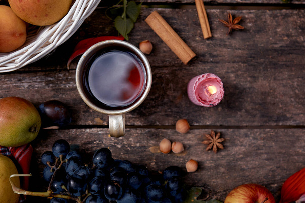 Rustikales, gemütliches Stillleben: Tasse Tee, Obst, Gemüse, Haselnüsse und Zimtstangen von oben. Herbstliches ästhetisches Stillleben mit Tasse und Kerze. Konzept zum Erntedankfest - Foto, Bild