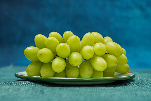 bunch of white italian dessert grapes. Image with various shades of green and turquoise blue for background - Photo, Image