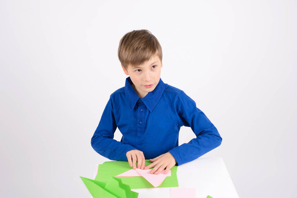 Leidenschaft Origami:, aufmerksam zuhören Junge, das fertige Produkt Origami - Papierbasteln - Foto, Bild