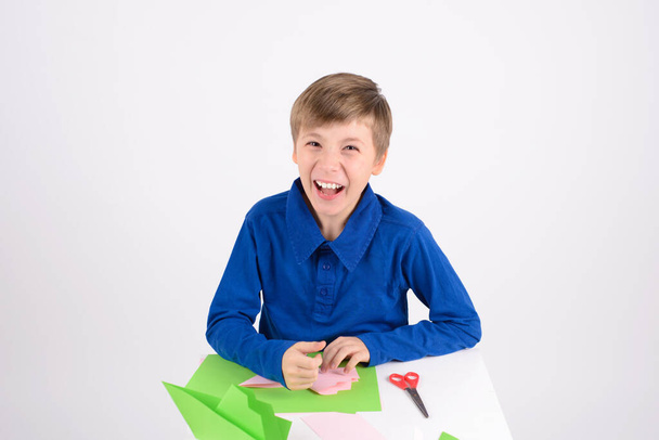 πάθος origami: πολύ διασκεδαστικό αγόρι γέλιο, το τελικό προϊόν origami - βιοτεχνία χαρτιού - Φωτογραφία, εικόνα