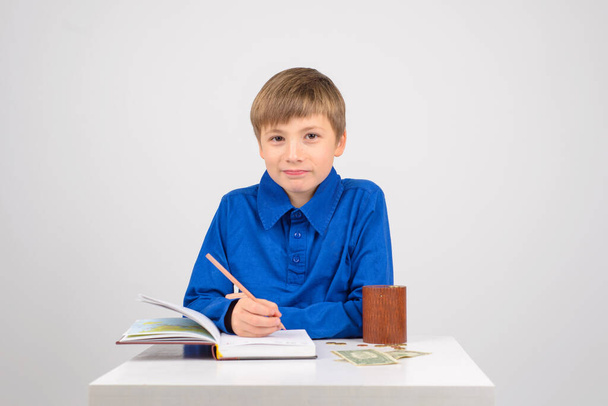 young businessman Young smart boy writes in a notebook with financial note - Photo, Image