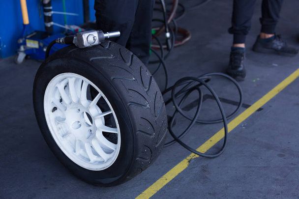 Air wrench and Tire waiting to get into action  replacement tire. - Valokuva, kuva