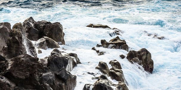 Побережье с камнями вулканического потока и океана
 - Фото, изображение